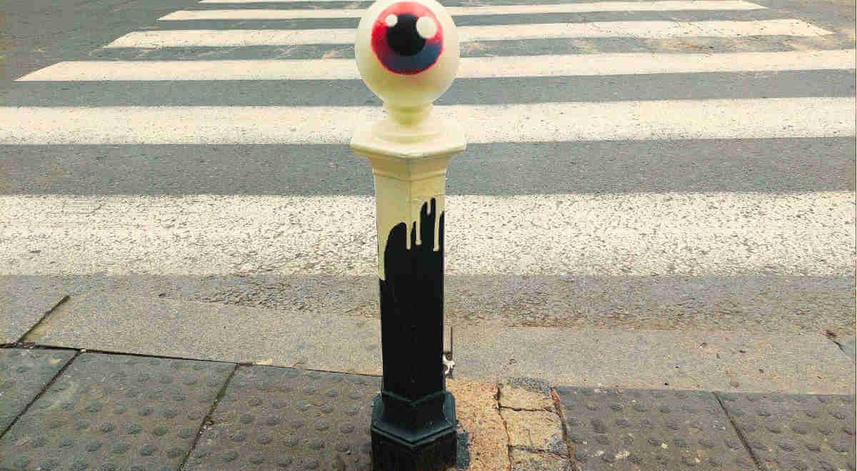 Le CyKlop's signature eye painted on the ball-shaped tip of once black and now colorful pillars in the center of Belgrade.