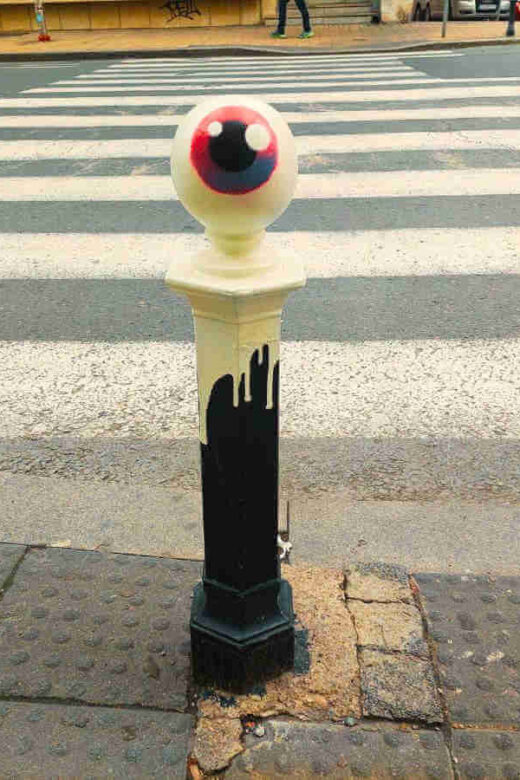 Le CyKlop's signature eye painted on the ball-shaped tip of once black and now colorful pillars in the center of Belgrade.