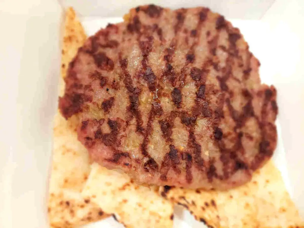 Pljeskavica served with somun bread in a self-service restaurant